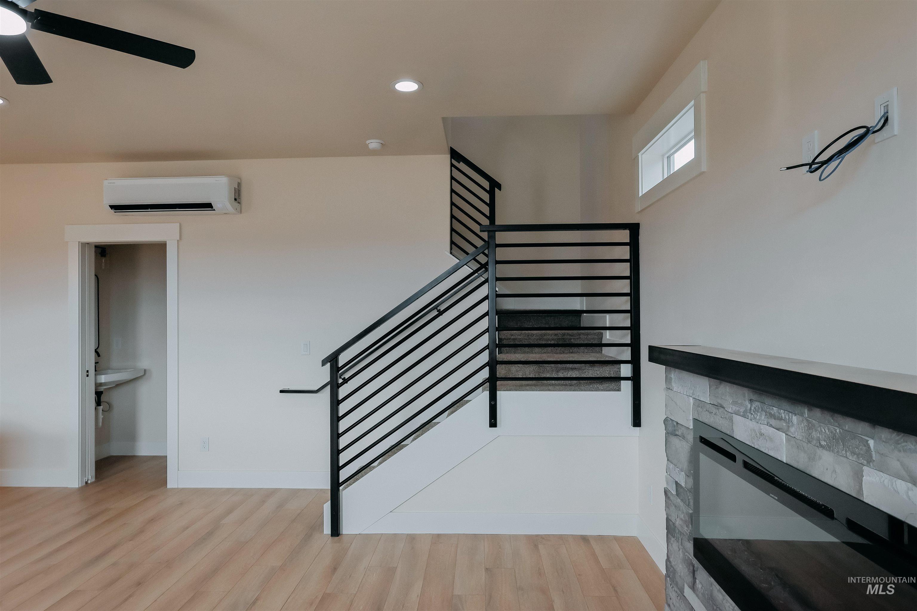 10 North Crk Way Cascade, ID 83611 - Photo 7 of 24 Staircase featuring wood finished floors, a ceiling fan, a stone fireplace, and recessed lighting