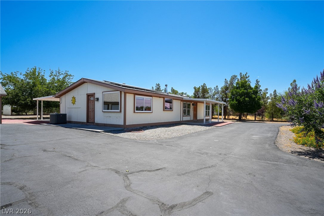 1831 West Horn Road Pahrump, NV 89048 - Photo 31 of 59 A long paved driveway leads to this charming, single-story residence with a covered porch.