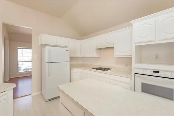 a kitchen with white cabinets and white appliances