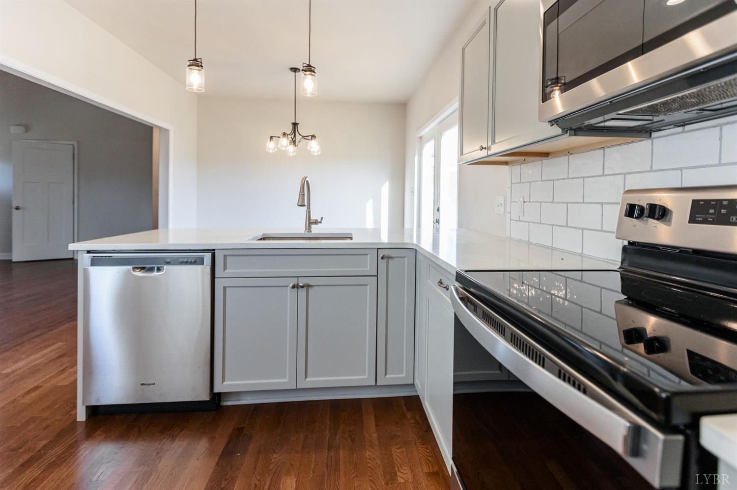 245 Country Estates Road Appomattox, VA 24522 - Photo 11 of 41 a kitchen with granite countertop a stove and a wooden floor