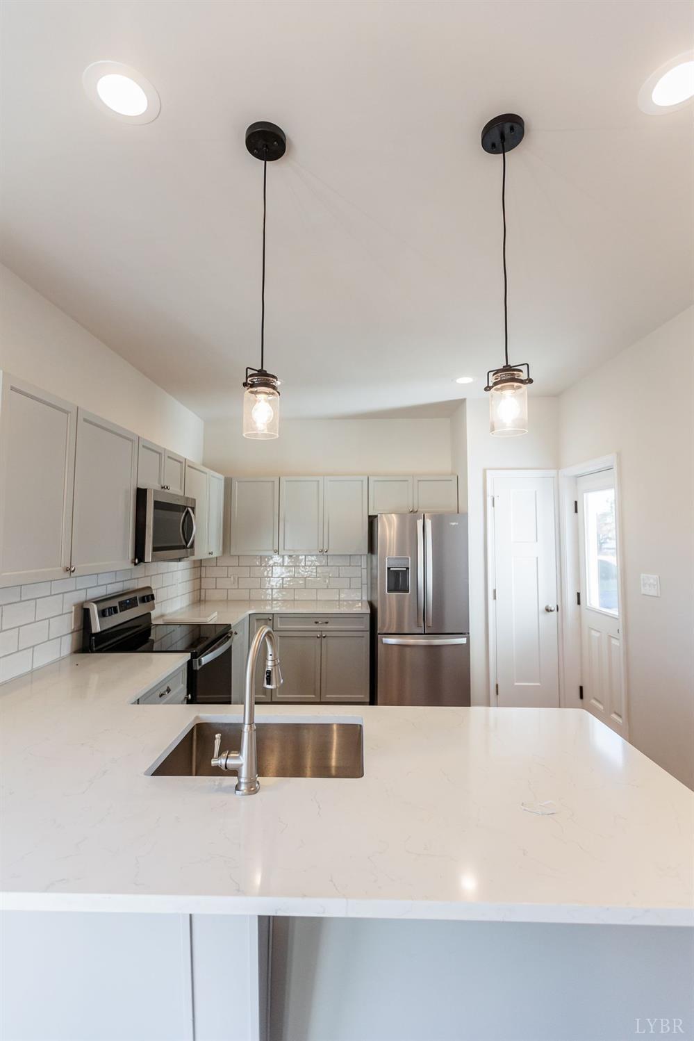 245 Country Estates Road Appomattox, VA 24522 - Photo 13 of 41 a large kitchen with kitchen island a counter space a sink and appliances