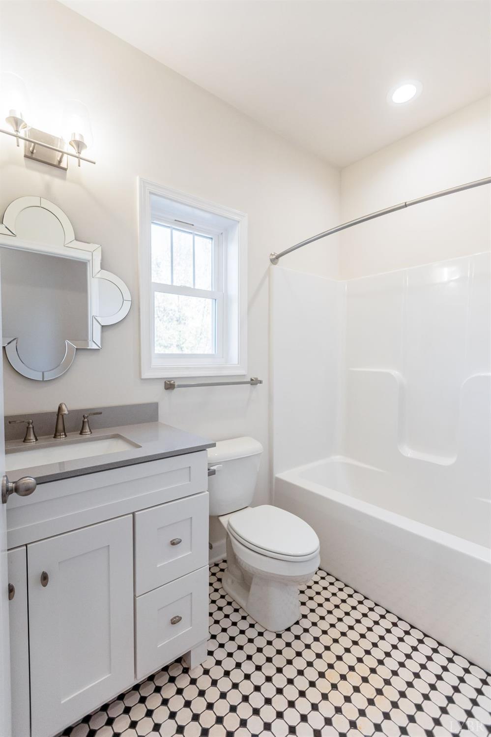 245 Country Estates Road Appomattox, VA 24522 - Photo 23 of 41 a bathroom with a granite countertop sink a toilet a mirror a bathtub and shower