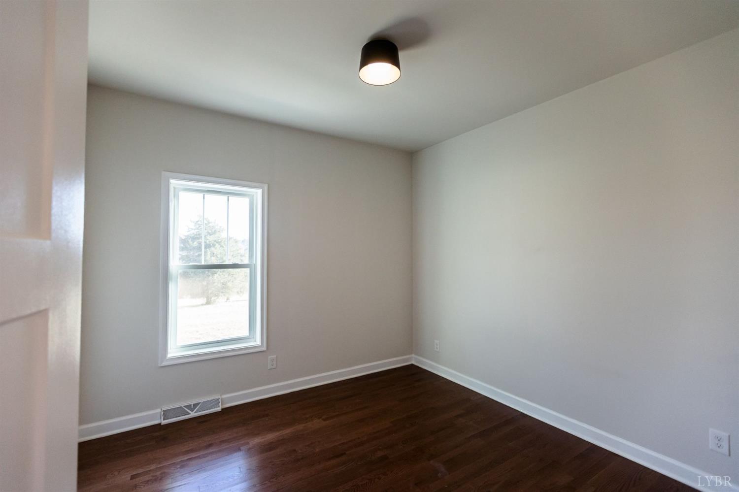245 Country Estates Road Appomattox, VA 24522 - Photo 31 of 41 an empty room with wooden floor and windows