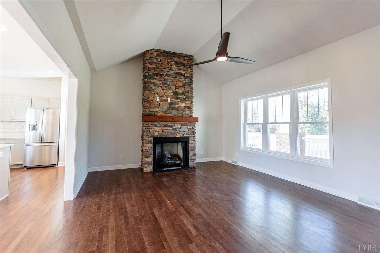 245 Country Estates Road Appomattox, VA 24522 - Photo 9 of 41 an empty room with wooden floor fireplace and windows