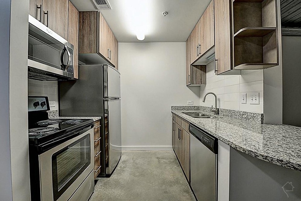 3550 Main Street, Unit 5301 Houston, TX 77002 - Photo 3 of 49 The kitchen features a modern design with stainless steel appliances, granite countertops, and wooden cabinetry. It offers a compact layout with ample storage and a sleek, contemporary finish.