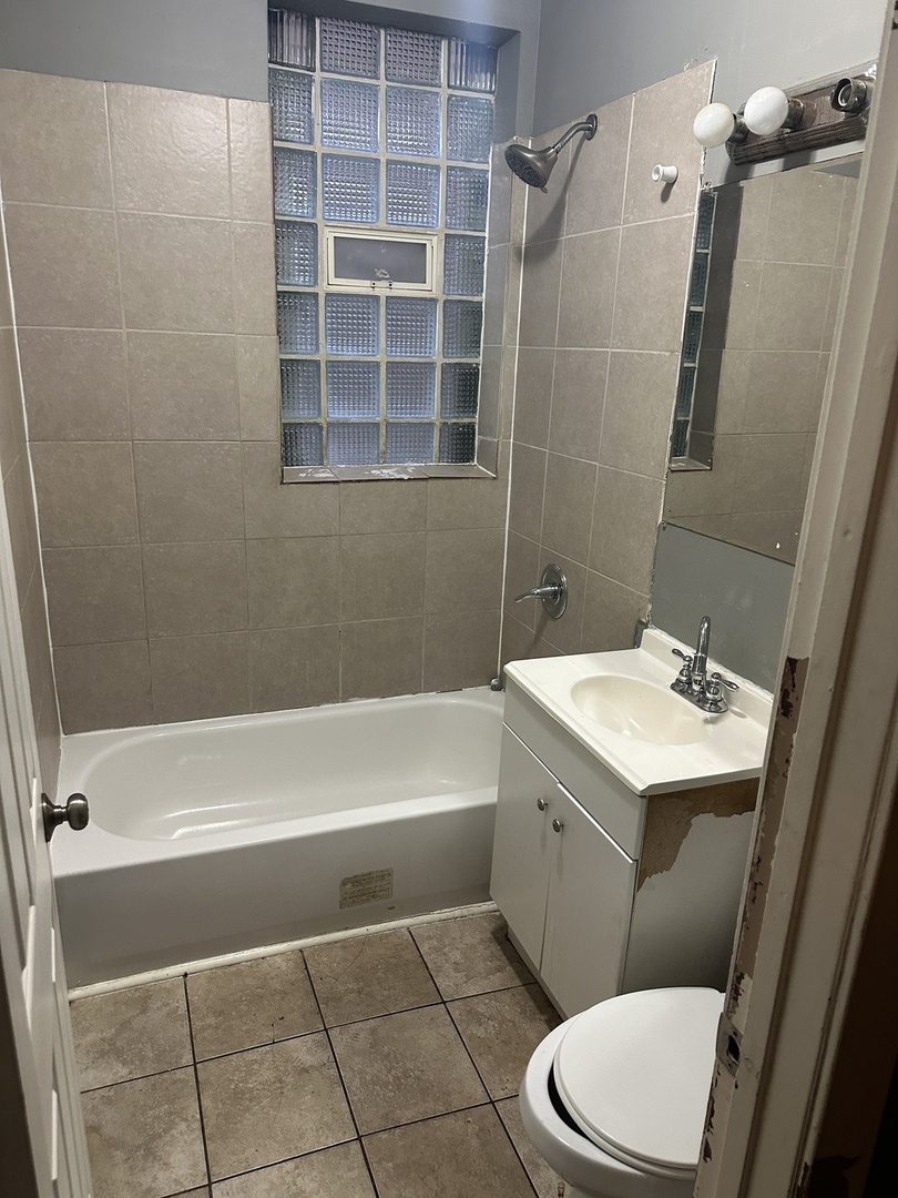 7216 South Green Street Chicago, IL 60621 - Photo 13 of 19 a bathroom with a sink a toilet and shower