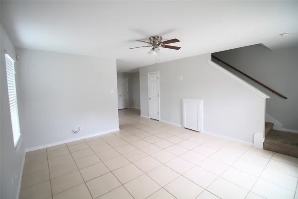 a view of a livingroom with a chandelier fan and windows