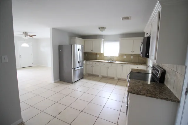 a kitchen with cabinets and steel appliances