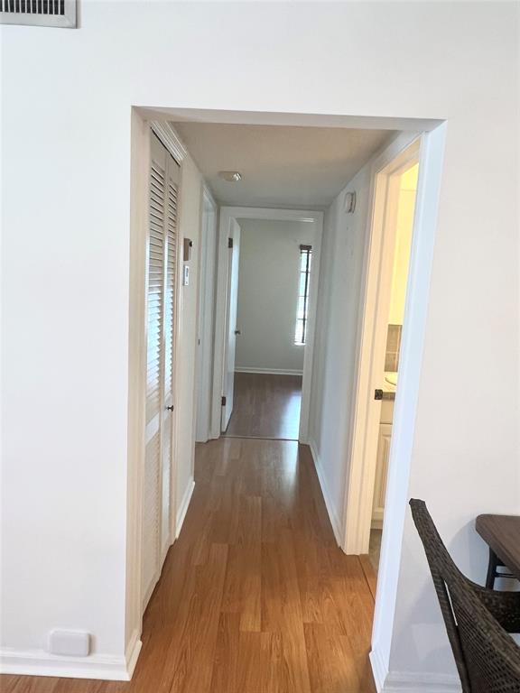 6600 Northeast 22nd Way, Unit 2332 Fort Lauderdale, FL 33308 - Photo 8 of 29 a view of a hallway with wooden floor and furniture