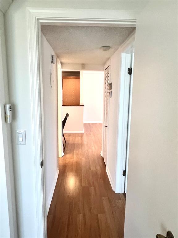 6600 Northeast 22nd Way, Unit 2332 Fort Lauderdale, FL 33308 - Photo 9 of 29 a view of a hallway with wooden floor and a bathroom