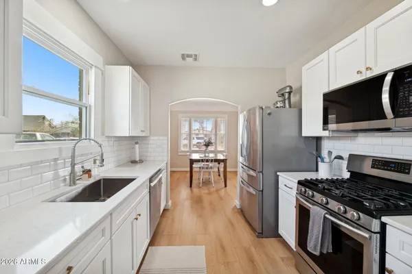 a kitchen with stainless steel appliances a sink stove and refrigerator