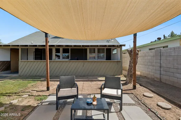 a view of a patio with table and chairs with wooden floor and fence