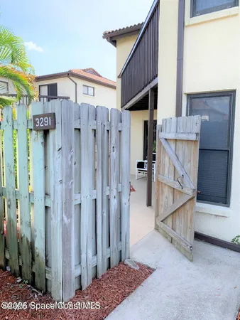 a view of a house with a wooden fence