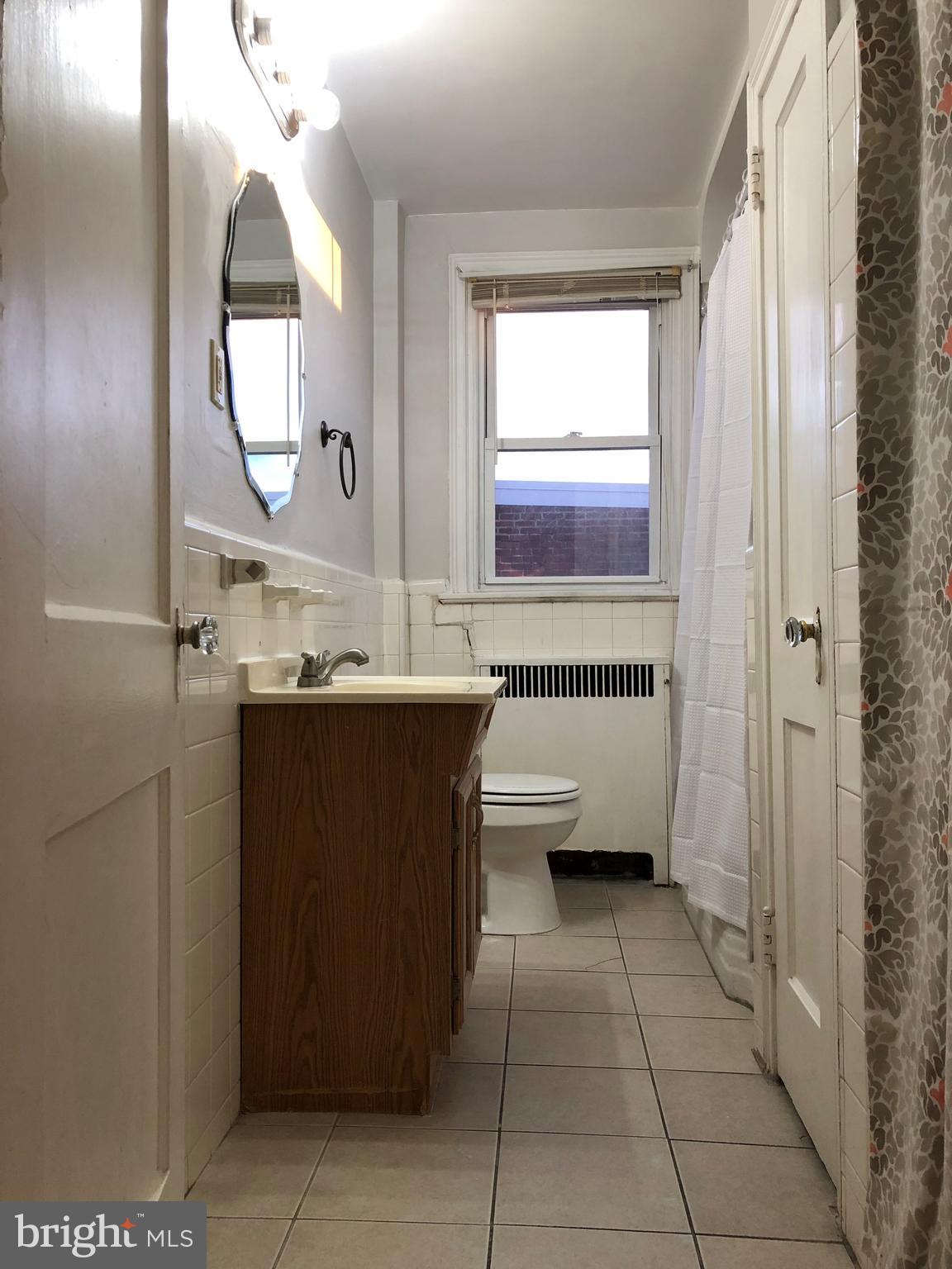 7558 Mayland Street, Unit 2 Philadelphia, PA 19138 - Photo 6 of 8 a bathroom with a sink a mirror and a bathtub