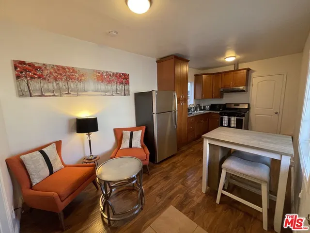 a kitchen with stainless steel appliances wooden floor dining table and chairs