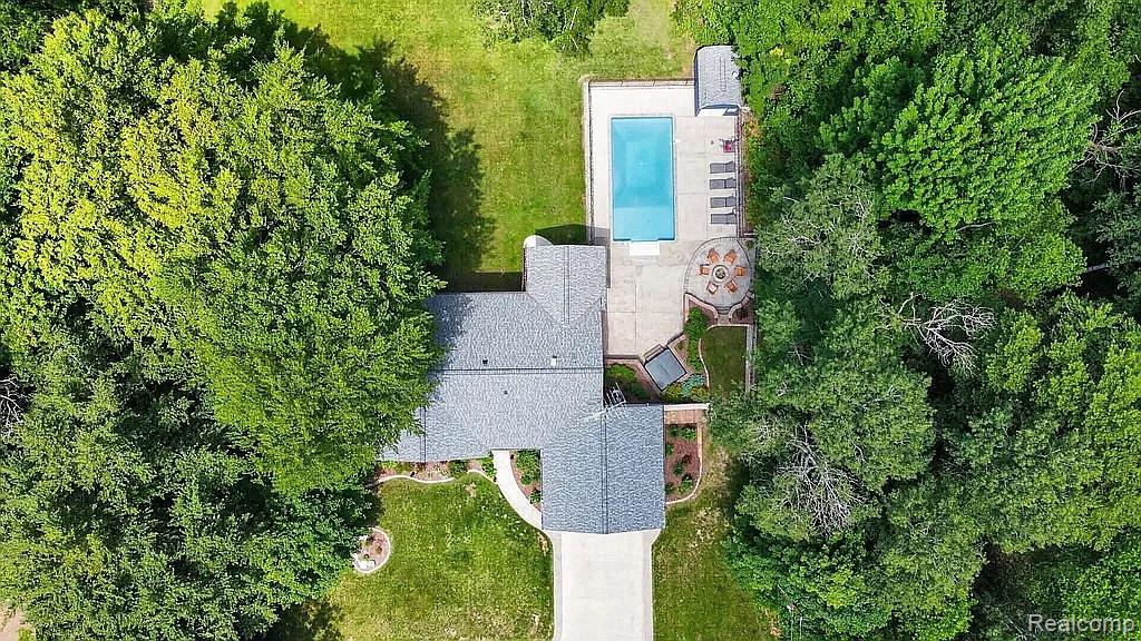 1555 Thompson Road Bad Axe, MI 48413 - Photo 14 of 14 Shingle roof residence with an in-ground swimming pool, concrete patio, and mature trees