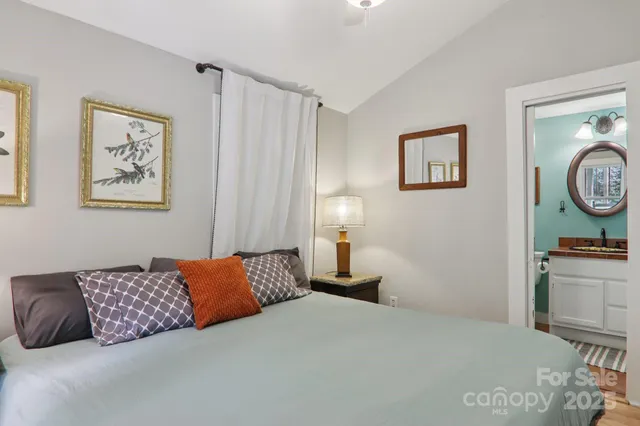 a bedroom with a bed and painting on the wall