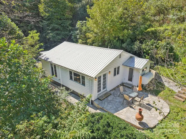 an aerial view of a house with yard porch and furniture