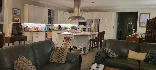 a living room with furniture and kitchen view