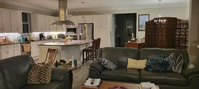 a living room with furniture a chandelier and a table