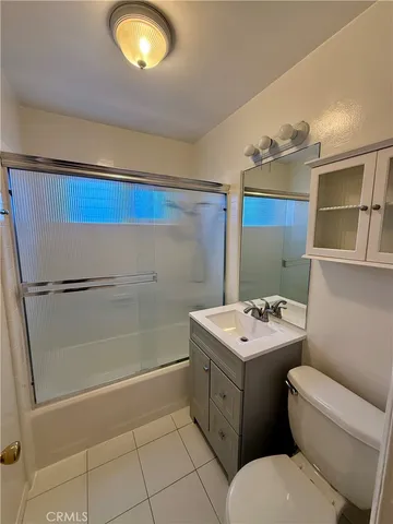a bathroom with a toilet sink vanity and mirror