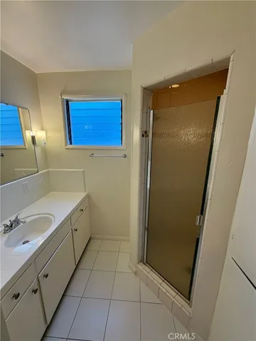 a bathroom with a double vanity sink a mirror and a shower