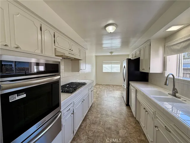 a kitchen with stainless steel appliances granite countertop a stove a sink and a refrigerator
