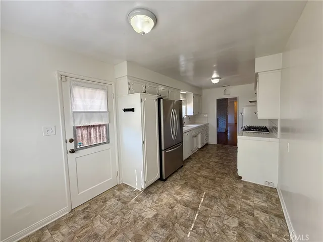 a kitchen with refrigerator and cabinets