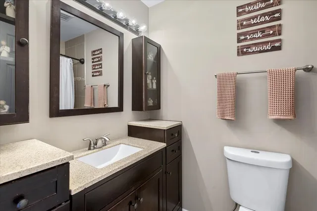 a bathroom with a sink a toilet and mirror