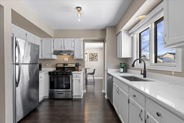 a kitchen with stainless steel appliances granite countertop a refrigerator sink and stove