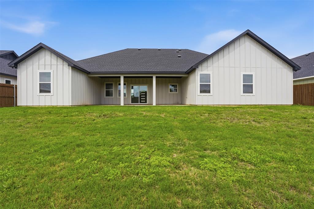532 Highview Court Godley, TX 76044 - Photo 38 of 39 Expansive green lawn backing a contemporary residence with board-and-batten siding