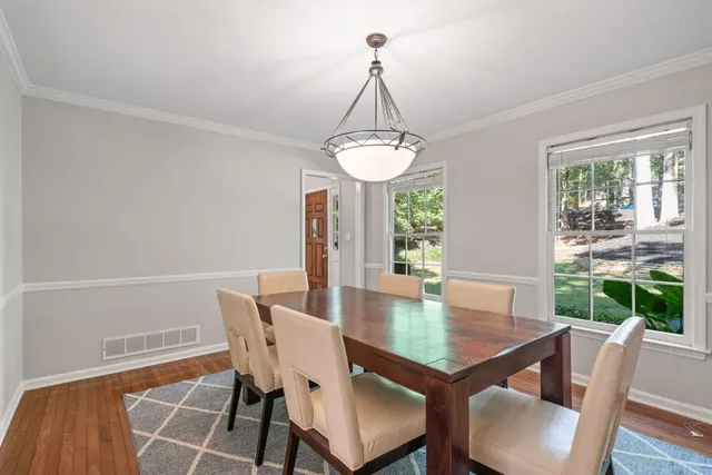a dining room with furniture a chandelier and wooden floor