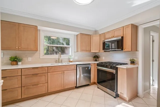 a kitchen with cabinets appliances and a window
