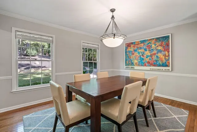 a view of a dining room with furniture a chandelier and wooden floor