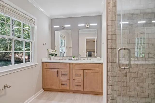 a bathroom with a double vanity sink a mirror and a shower