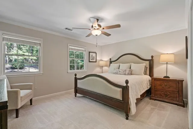 a bedroom with a bed a table and a chandelier