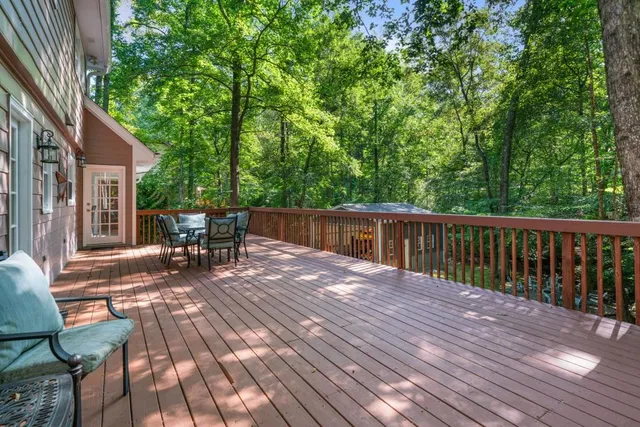 a view of backyard with a table and chairs with wooden floor and fence