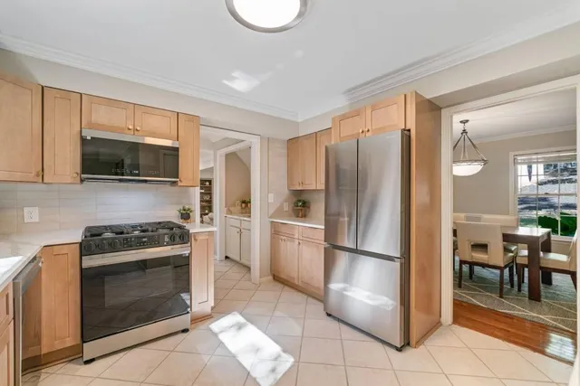 a kitchen with granite countertop a refrigerator stove and microwave
