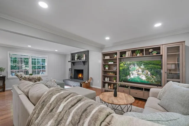 a living room with furniture a large window and a flat screen tv