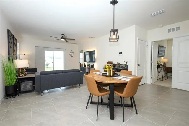 a kitchen with stainless steel appliances granite countertop table chairs sink and cabinets