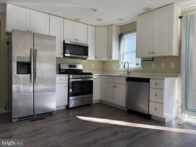 a kitchen with stainless steel appliances a stove a sink and a refrigerator