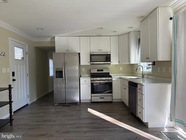 a kitchen with kitchen island granite countertop a refrigerator and a stove top oven
