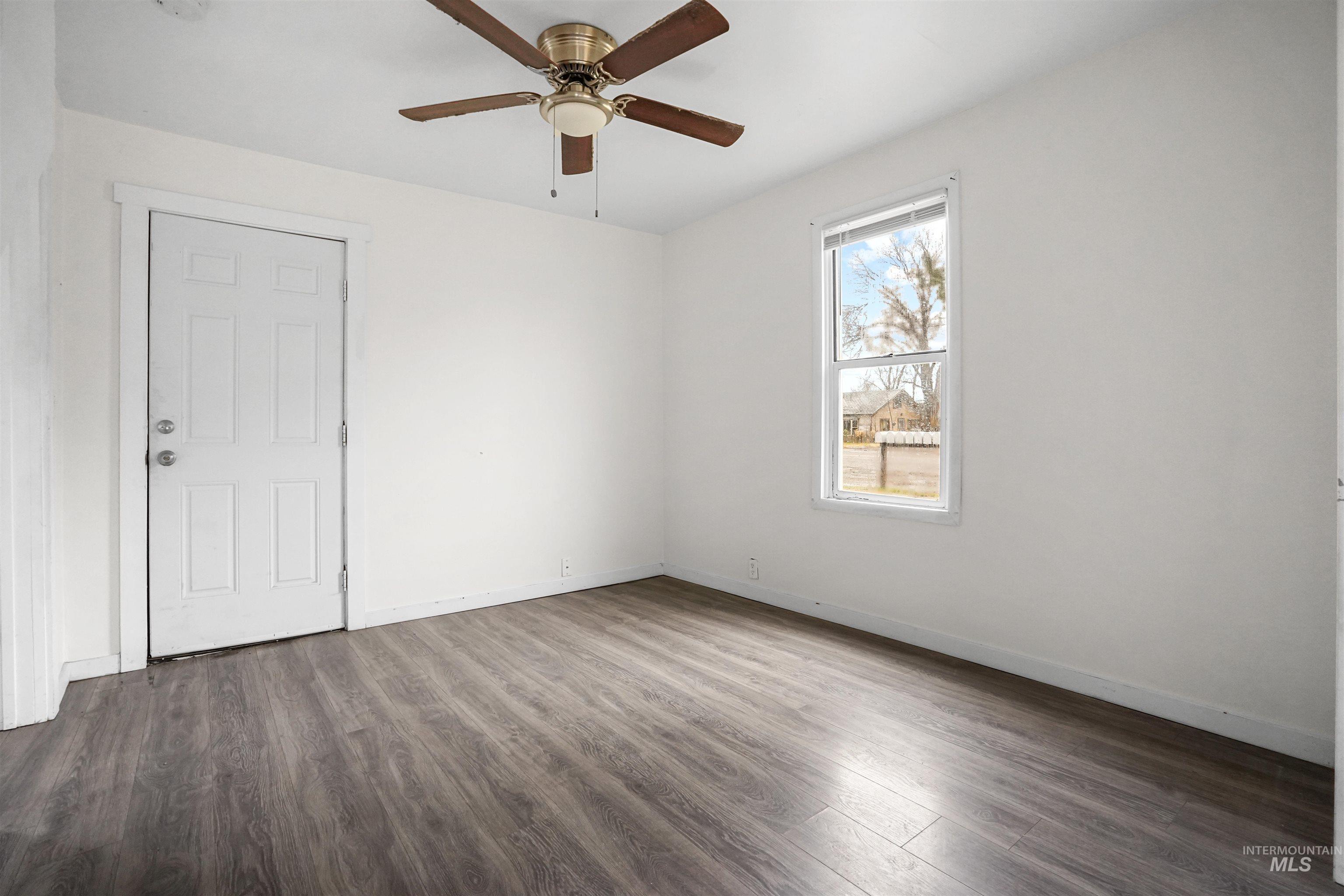 324 Linden Street Rupert, ID 83350 - Photo 2 of 13 Empty room with wood finished floors and a ceiling fan