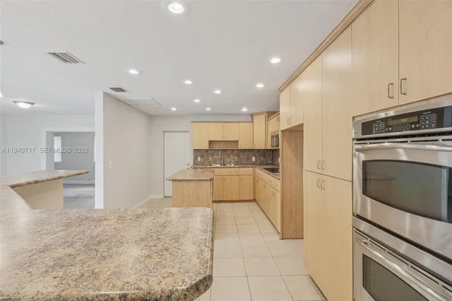 a view of kitchen with stainless steel appliances refrigerator microwave and stove