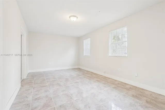 a view of an empty room with window and closet area
