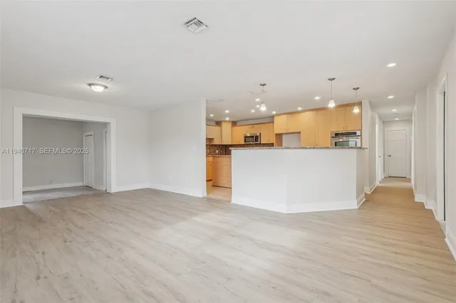 a view of a kitchen with a sink and a refrigerator