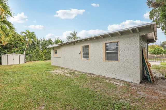 a view of a house with a backyard and a patio