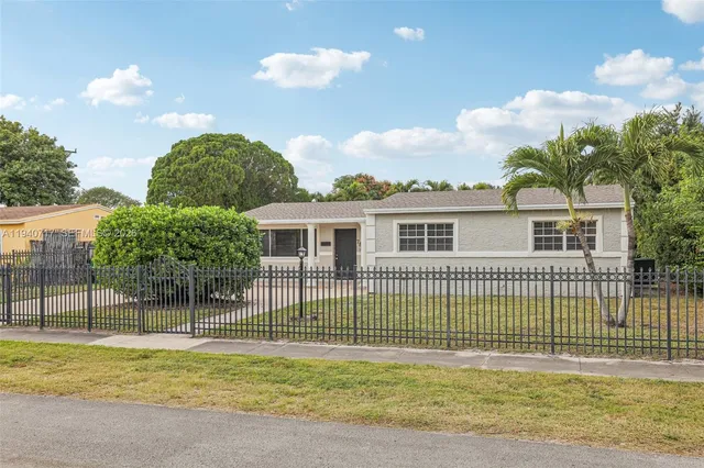a view of an house with a yard and potted plants