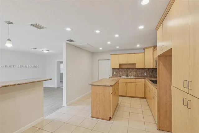 a large kitchen with stainless steel appliances granite countertop a sink and cabinets