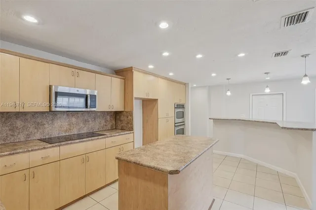 a kitchen with kitchen island a counter top space and a sink